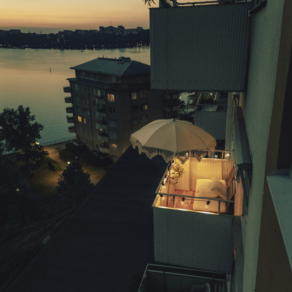 Ett flerfamiljshus där en av balkongerna är upplyst och ser inbjudande ut.